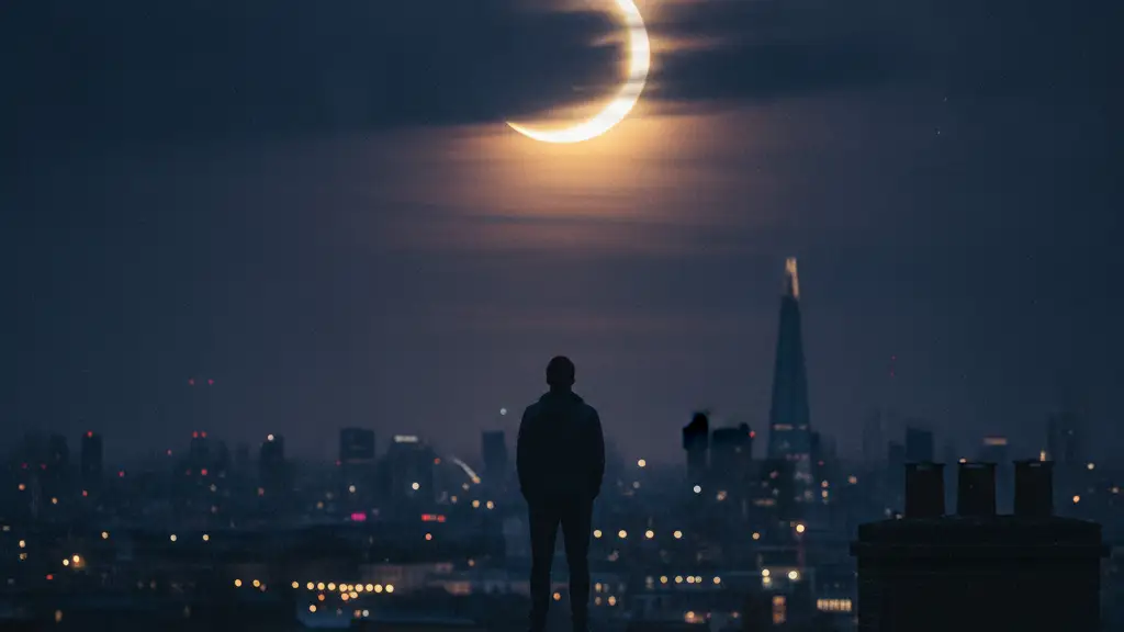 Silhouette of a person on a London rooftop watching a partial solar eclipse.