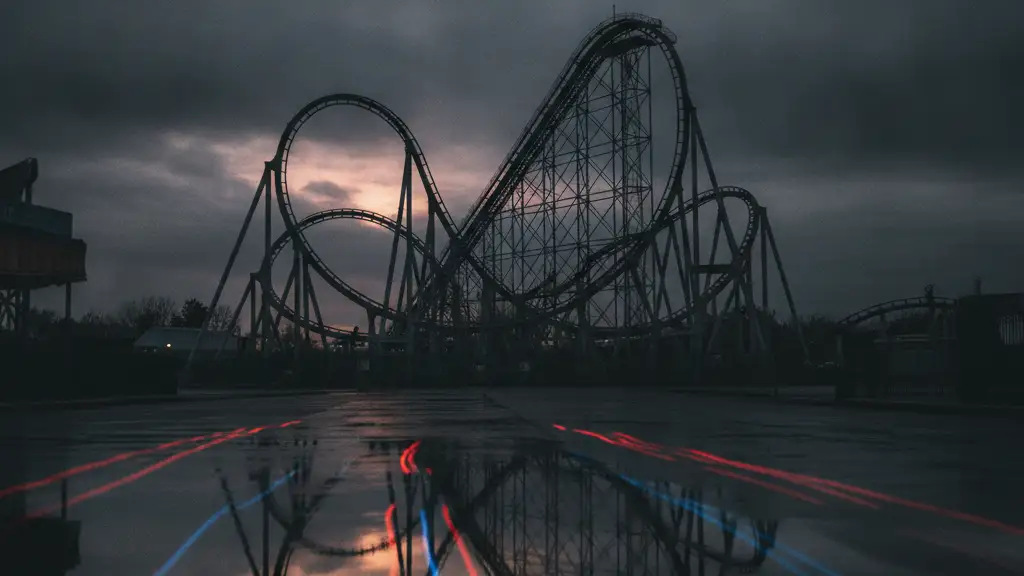 A deserted theme park ride silhouetted against a dramatic sky at dusk.