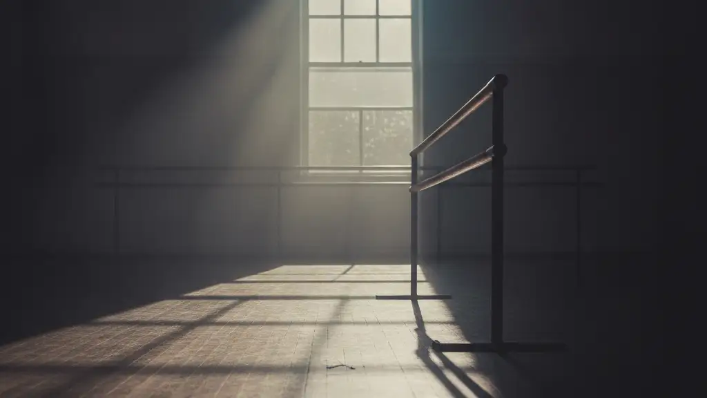 Empty ballet barre in a dimly lit dance studio, reflecting faint light.