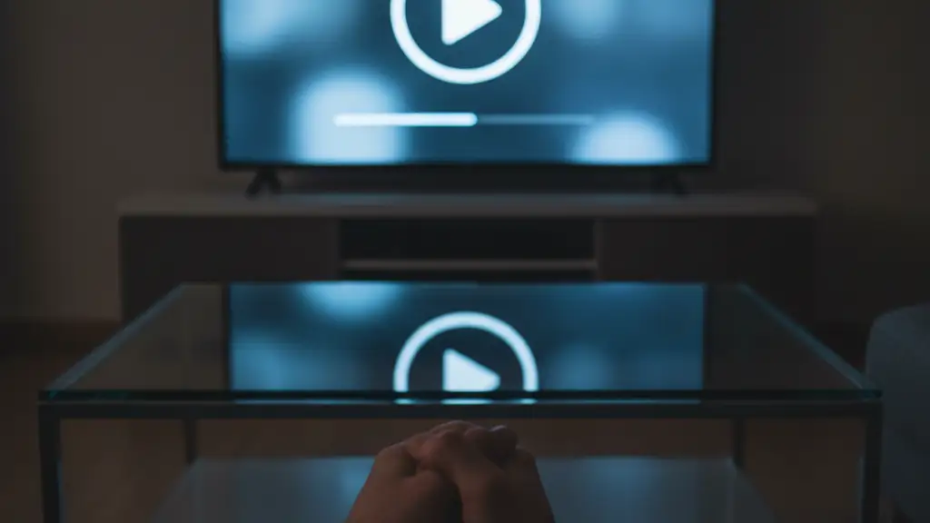 A television screen showing a documentary menu reflecting on a table in a dark room.