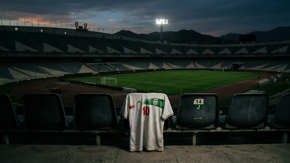 An empty football stadium at dusk with an Iranian jersey draped over a seat.