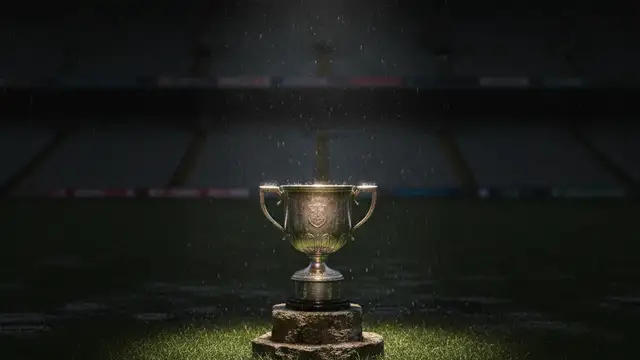 The Sam Maguire Cup sits alone on a rain-soaked Gaelic football pitch.
