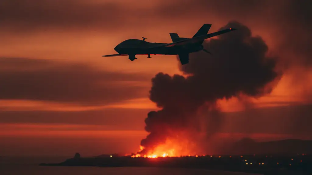 Silhouette of a military drone against a fiery, smoke-filled twilight sky over a coastline.