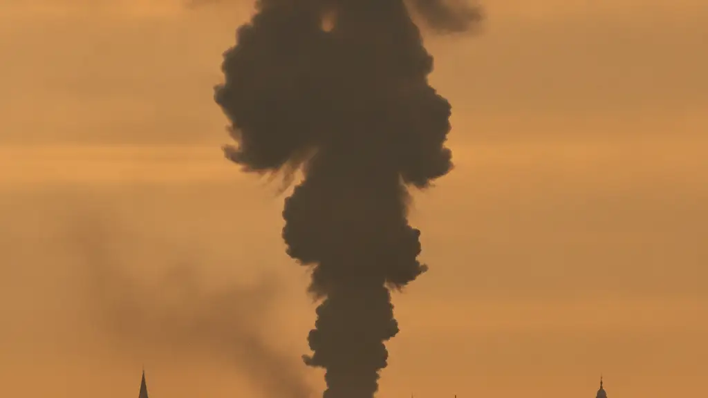 Thick smoke column rising over distant London rooftops under an orange sky.