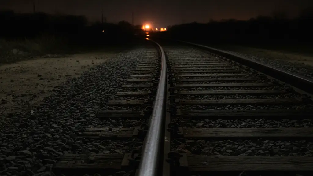 Close-up of a slightly misaligned railway track at night.