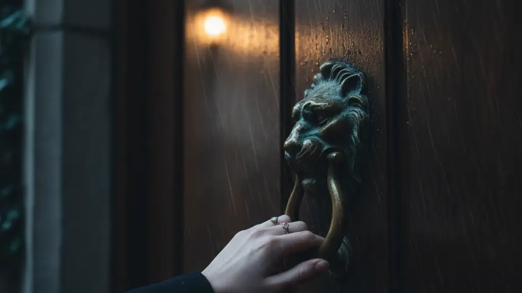 A woman's silhouetted hand reaching for a brass door knocker on a dark wooden door.