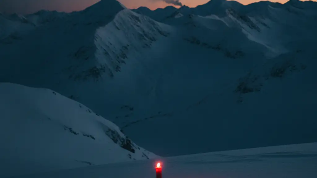 A single red emergency flare in vast, snow-covered mountains at dawn.