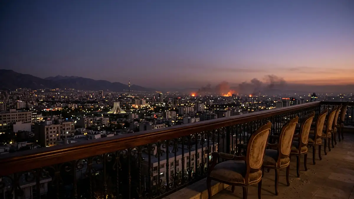 The Tehran skyline at dusk with distant orange glows and empty chairs in the foreground.