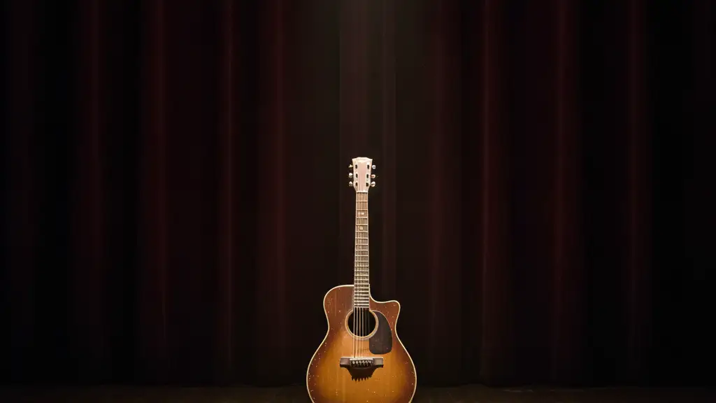 A lone vintage acoustic guitar on a stand under a single spotlight on an empty stage.