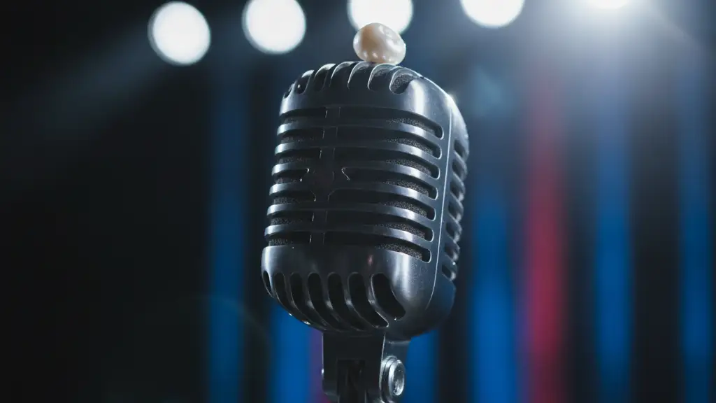 A small white object rests on a vintage microphone under bright stage lights.