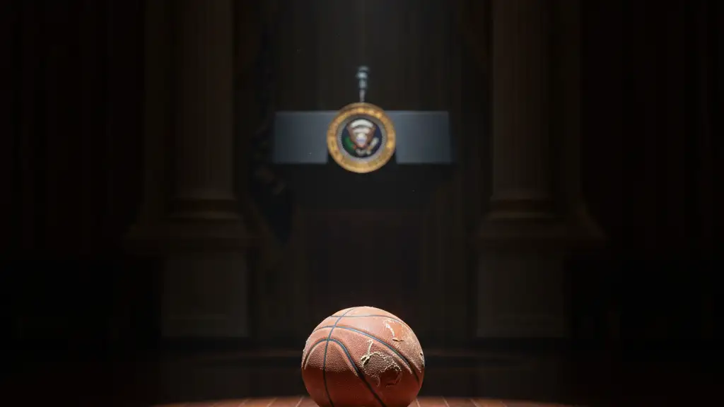 A deflated basketball on a polished floor, presidential seal blurred in background.