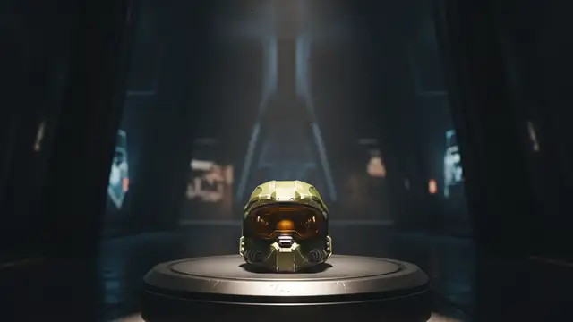 A lone Master Chief helmet on a pedestal in a dimly lit, futuristic setting.