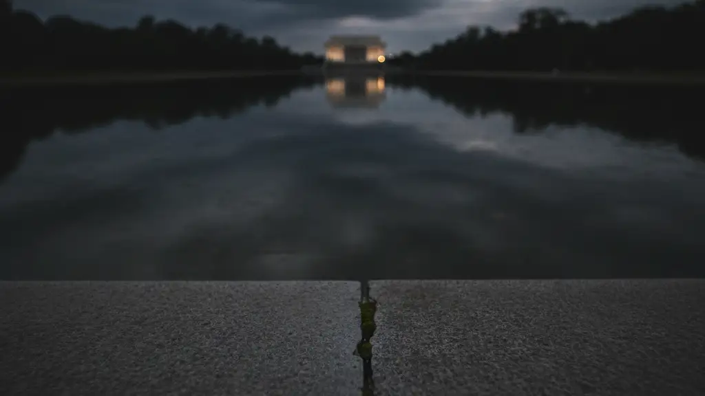 Subtle crack in Lincoln Memorial Reflecting Pool edge, blurred police tape foreground.