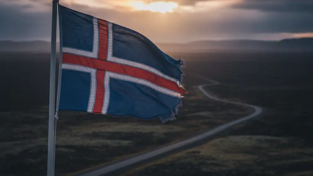 Weathered Icelandic flag against a dramatic, overcast sky.