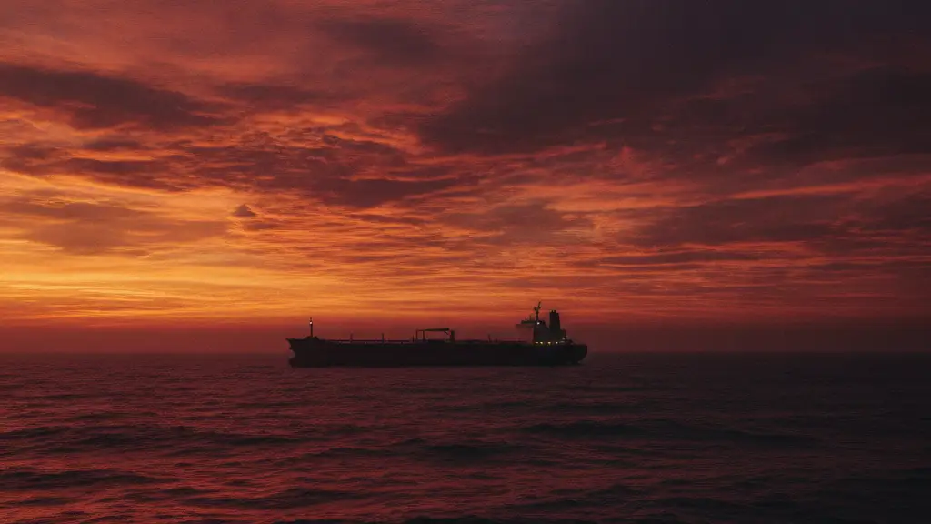 Silhouetted oil tanker against a fiery, abstract sunset on choppy red waters.