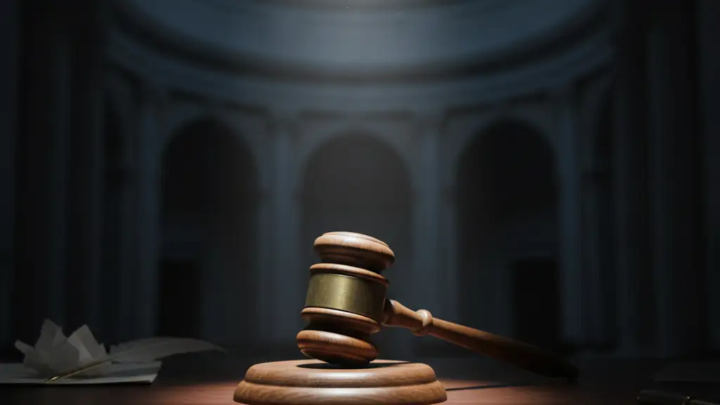A lone wooden gavel on a dark, polished desk under a dramatic spotlight.