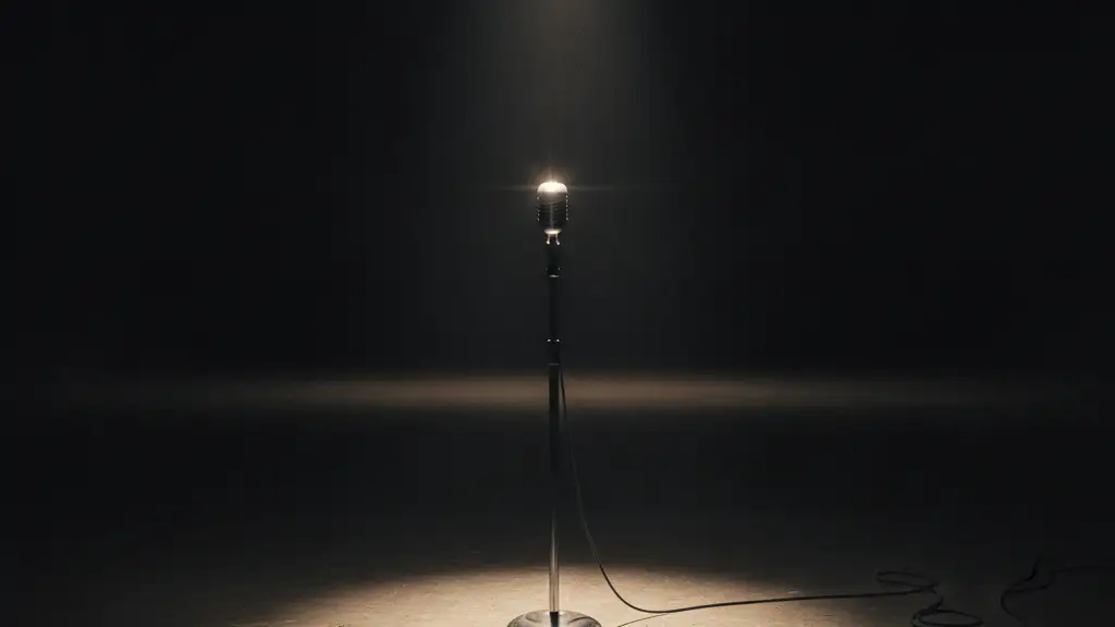 A lone microphone stand under a single spotlight on an empty television studio set.