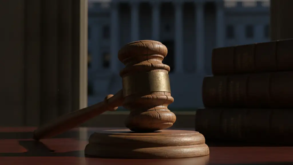 A heavy wooden gavel rests on a dark desk, courthouse steps blurred in background.