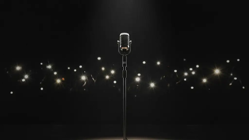 A lone microphone on a dark stage, with blurred paparazzi flashes in the background.