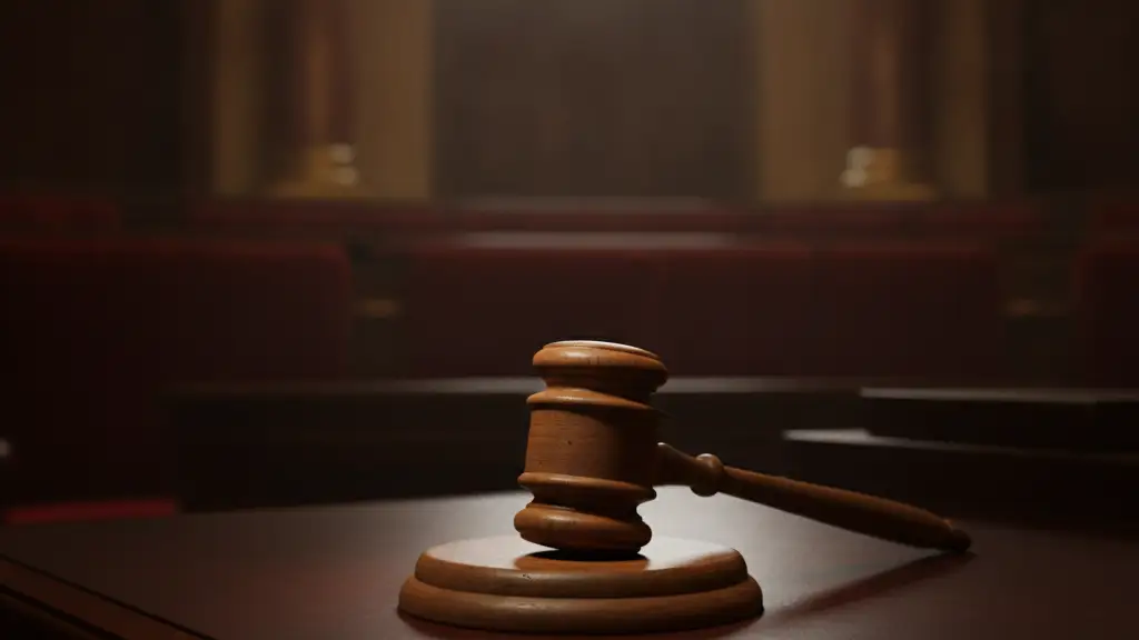 A heavy wooden gavel rests on a polished mahogany desk in a dimly lit office.