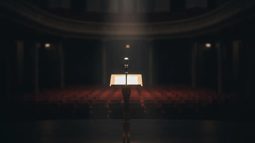 An empty podium with a microphone on a stage under a spotlight.