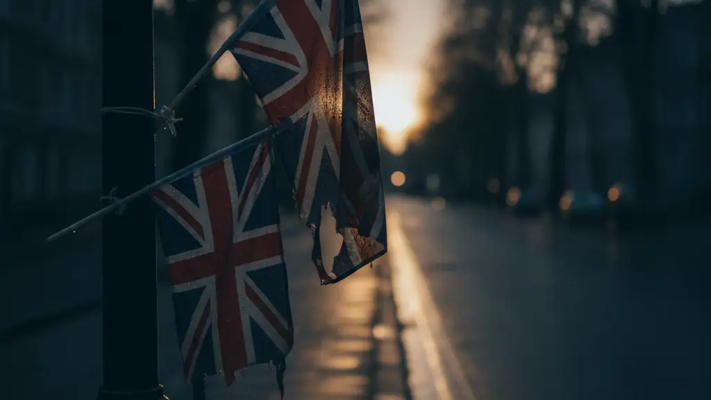 Union Jack and St. George's flags on a lamp post at dusk.
