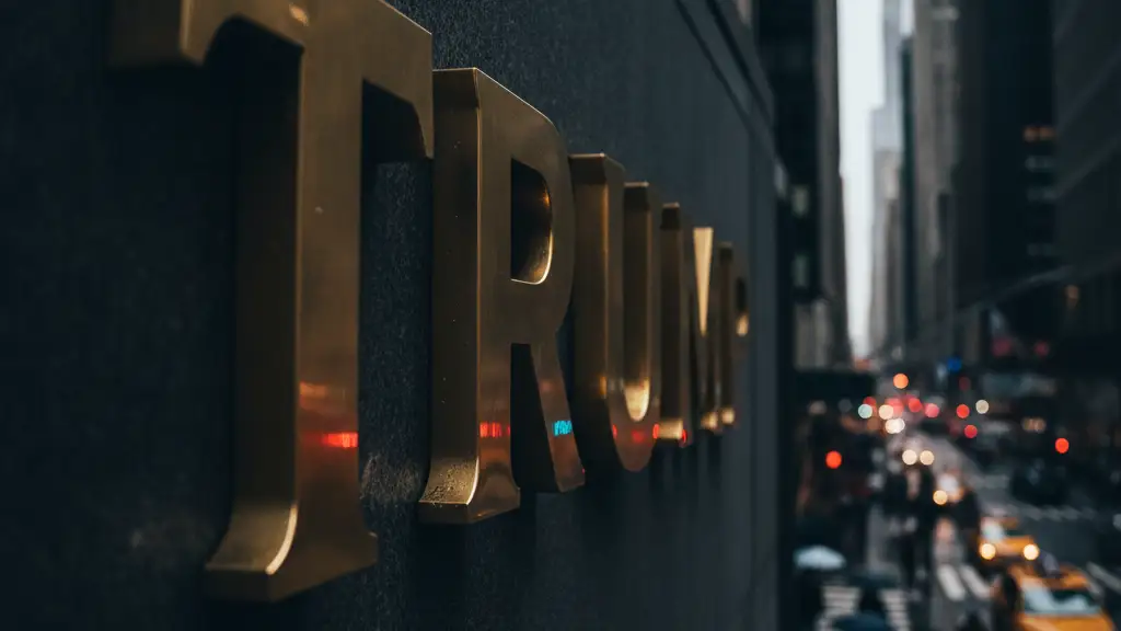 Gold 'TRUMP' lettering on Trump Tower reflecting city lights.