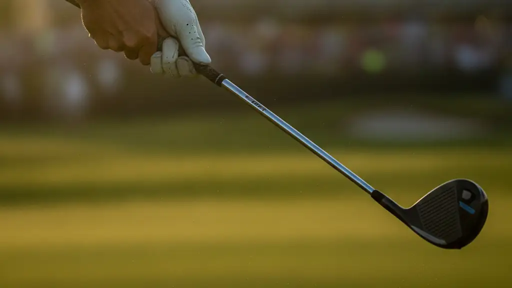Golfer's hands gripping a 3D-printed iron on a sun-drenched golf course.