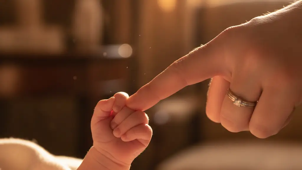 A newborn baby's tiny hand gently holding an adult's finger, conveying new life.