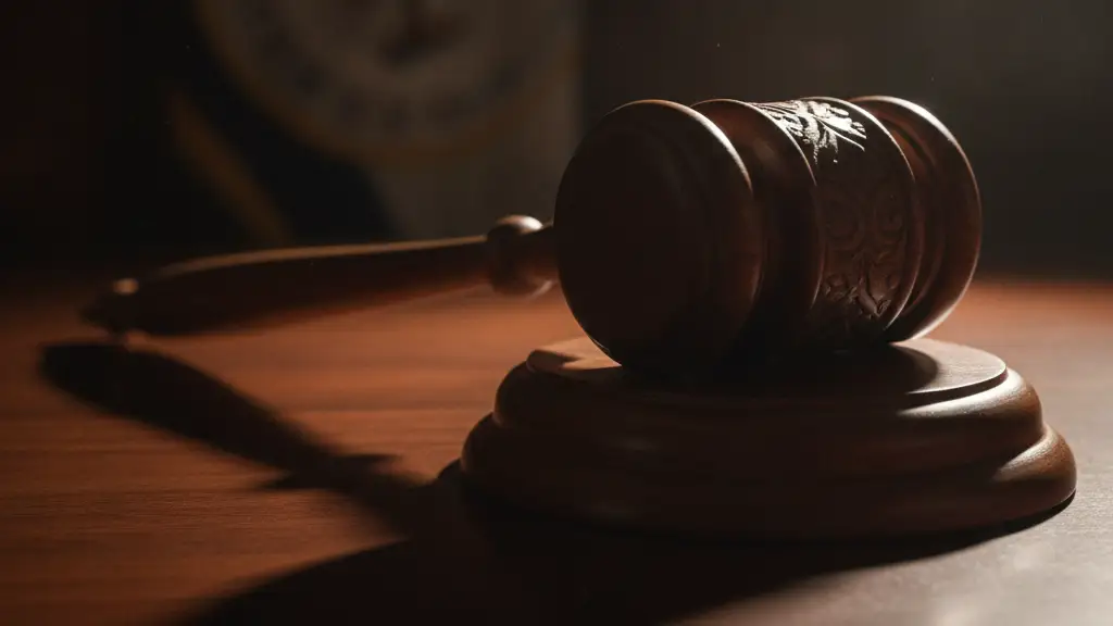A heavy wooden gavel rests on a polished mahogany desk, casting a dramatic shadow.