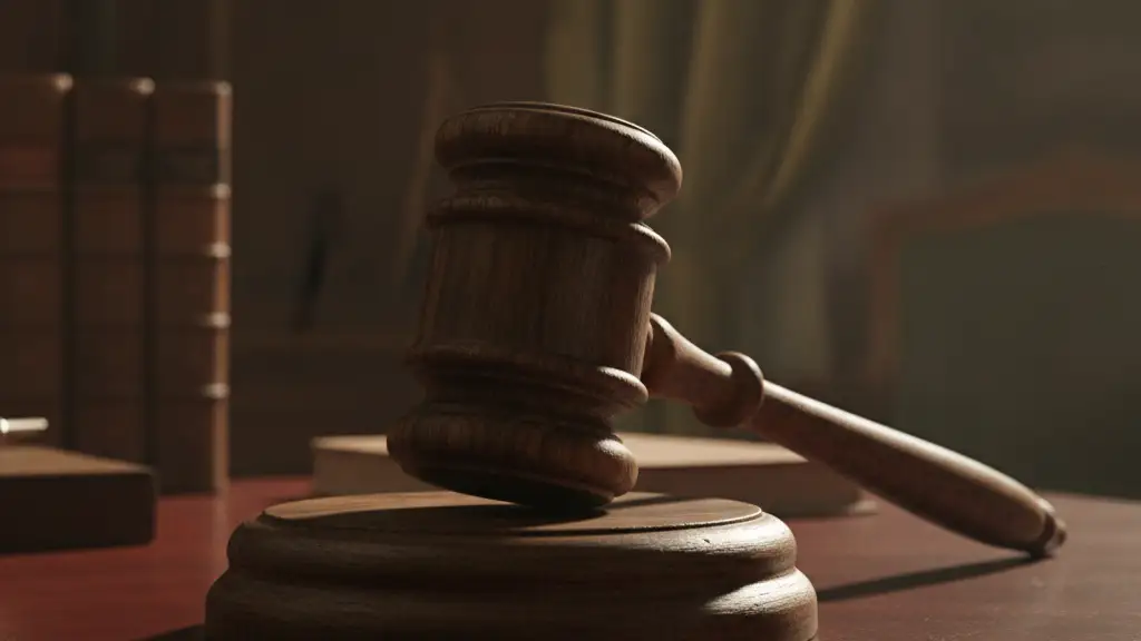 A heavy wooden gavel rests on a dark, polished mahogany desk.