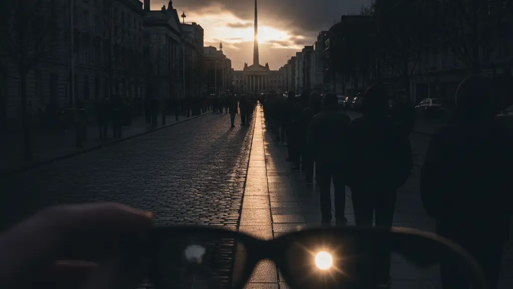 Silhouetted crowd queues on a Dublin street for eclipse glasses.
