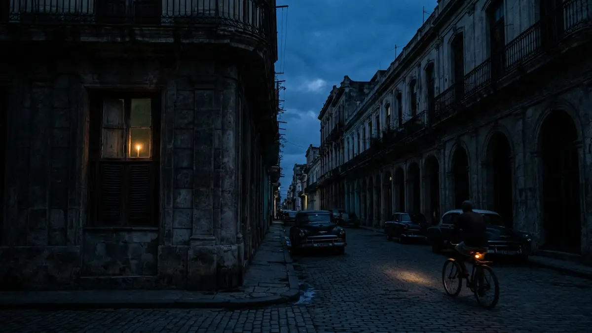 A dark Havana street at night with silhouettes of buildings and cars during a blackout.
