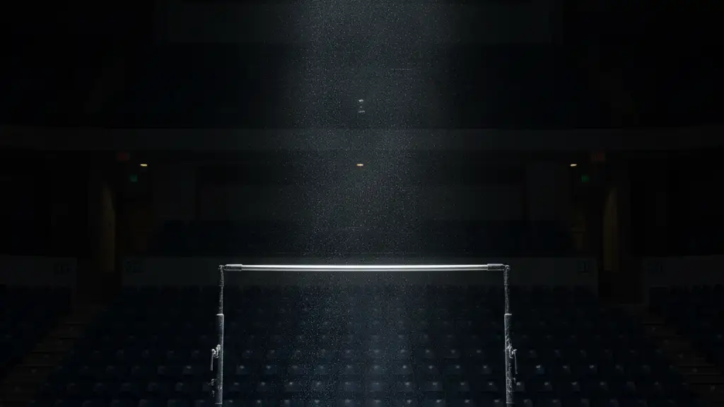 Empty gymnastics high bar under a single spotlight in a dark arena.