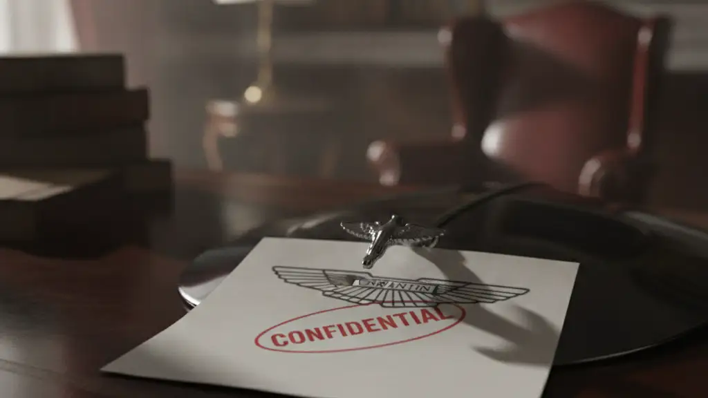 Aston Martin badge partially covered by a confidential document on a desk.