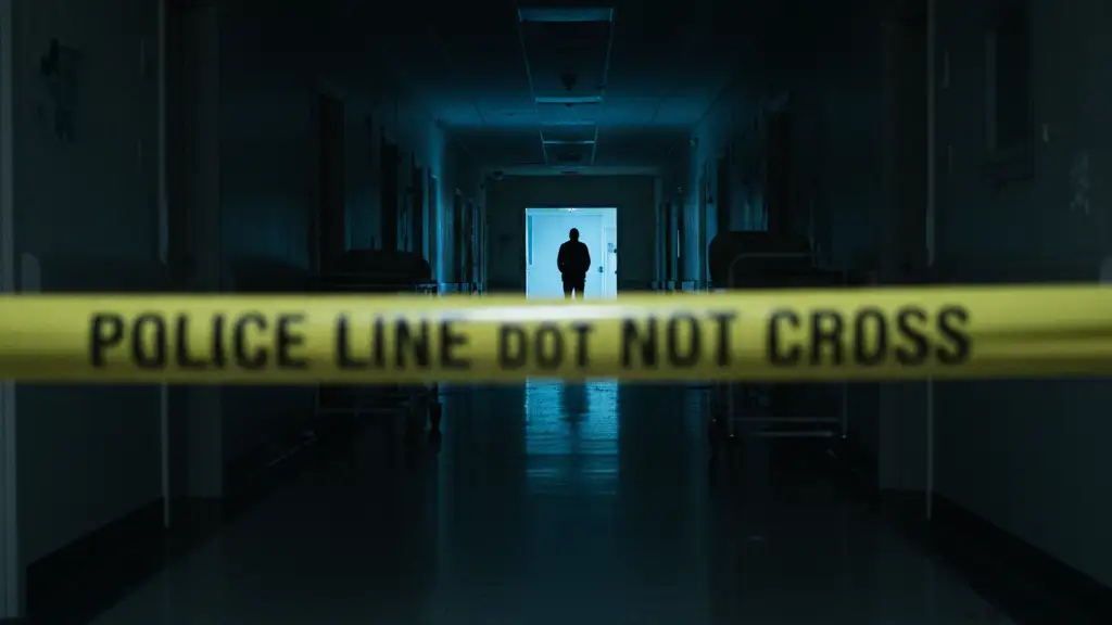 Empty hospital corridor with police tape and a distant silhouette.